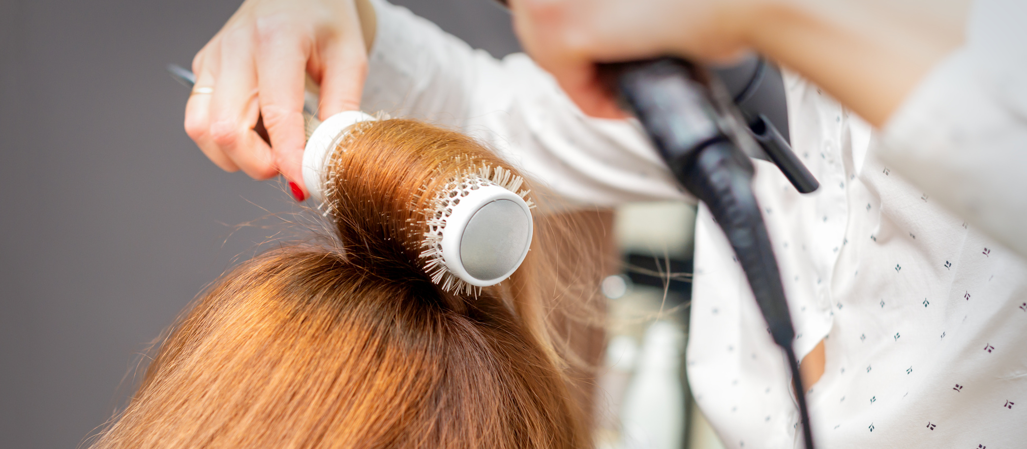 Drying Red Hair with a Hairdryer and round Brush, Close up.